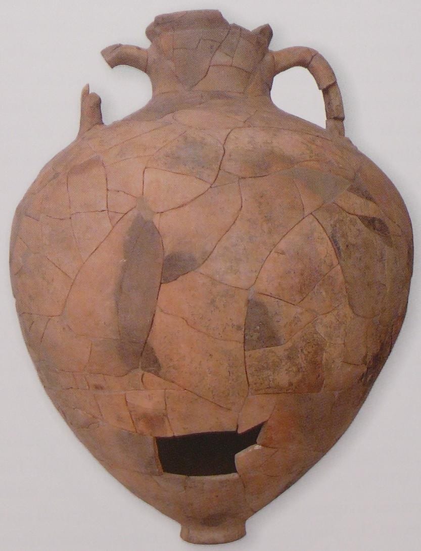 Grande vaso panciuto in ceramica chiara, ricomposto da decine di frammenti, con due anse e un vuoto nella pancia.