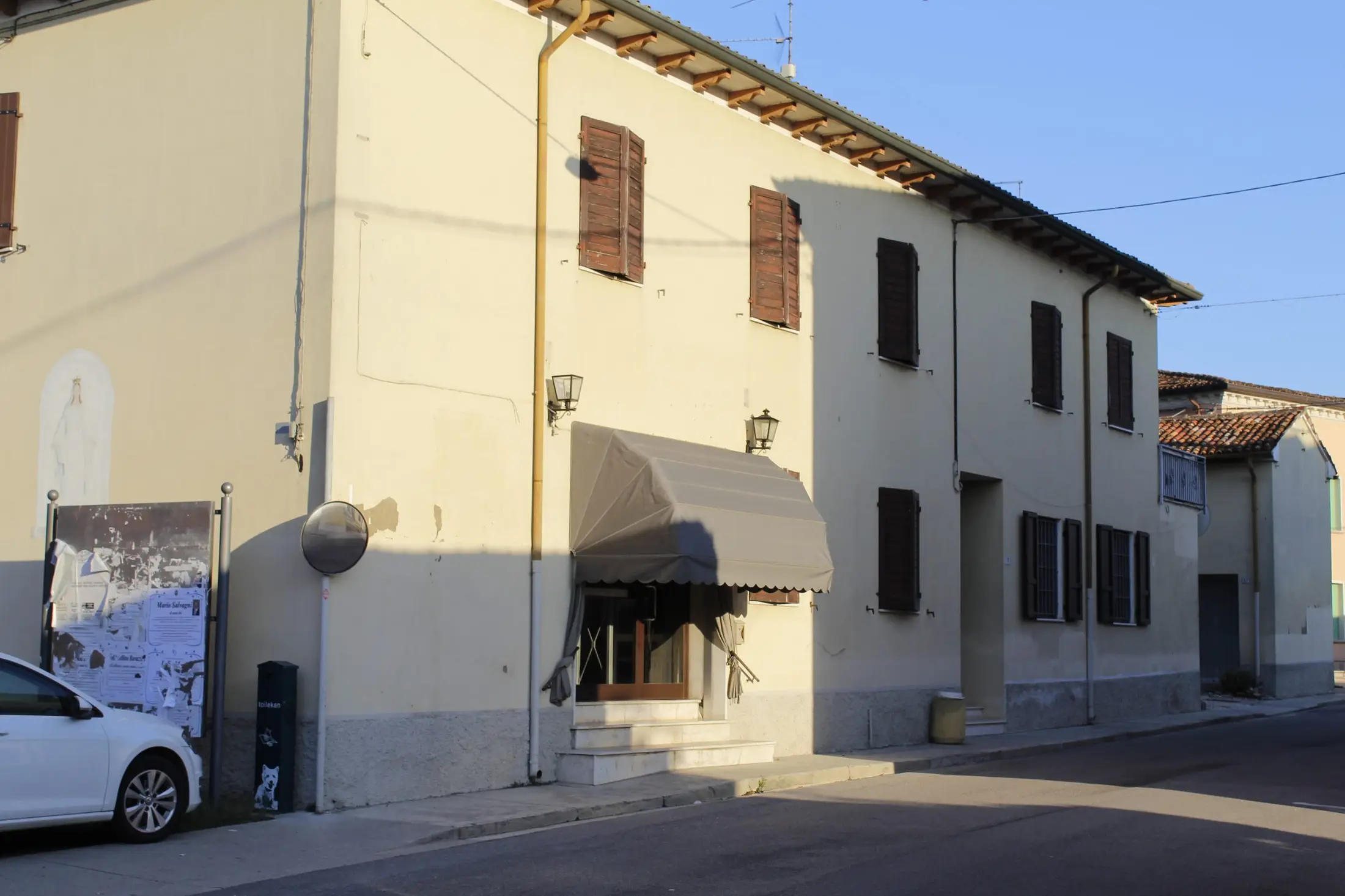 La Bottega Atipica in Via Gramsci: la tenda sopra la porta a vetri, in fondo all'edificio giallo